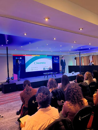 Andres y Gabriela de Libertate en el escenario de la Clínica DEI de Amcham dando el workshop con visualización del público espectador.