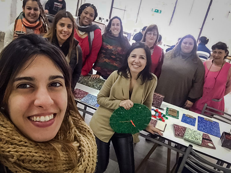 Equipo mostrando algunos de los productos elaborados con tapitas plásticas.